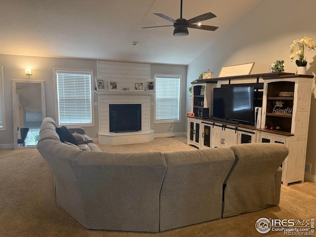 1460 Hawkridge Rd, Eaton, CO 80615 - living room featuring light colored carpet, a ceiling fan, a fireplace with raised hearth, and lofted ceiling