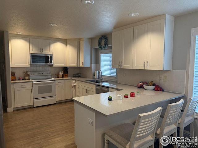 1460 Hawkridge Rd, Eaton, CO 80615 - kitchen featuring appliances with stainless steel finishes, white cabinets, dark wood-type flooring, tasteful backsplash, and a textured ceiling