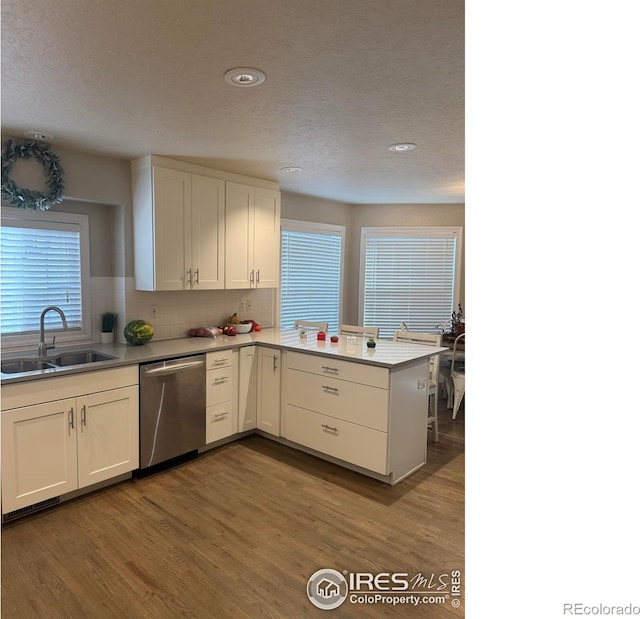 1460 Hawkridge Rd, Eaton, CO 80615 - kitchen with dishwasher, a peninsula, white cabinetry, wood finished floors, and decorative backsplash