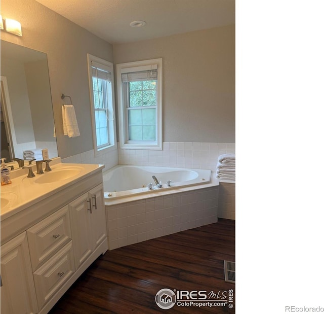 1460 Hawkridge Rd, Eaton, CO 80615 - bathroom featuring double vanity, a garden tub, and wood finished floors