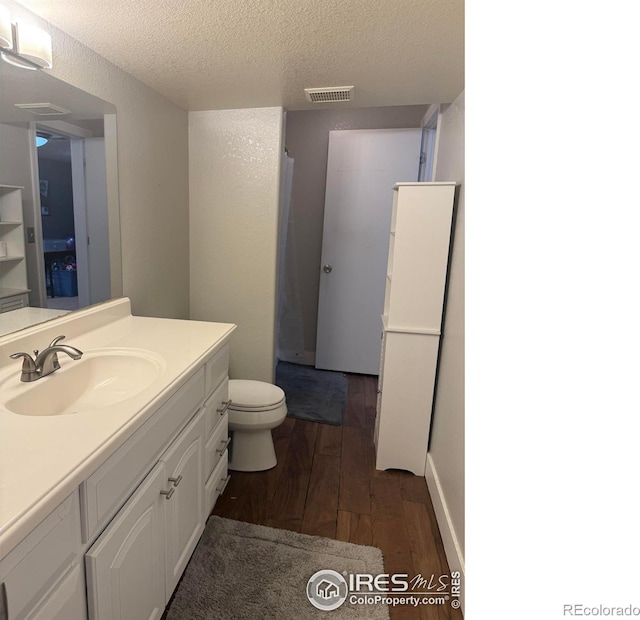 1460 Hawkridge Rd, Eaton, CO 80615 - bathroom with hardwood / wood-style flooring, vanity, and a textured ceiling