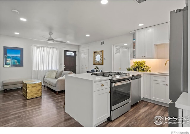 7131 Pontiac St, Commerce City, CO 80022 - kitchen with stainless steel appliances, a peninsula, recessed lighting, and white cabinetry