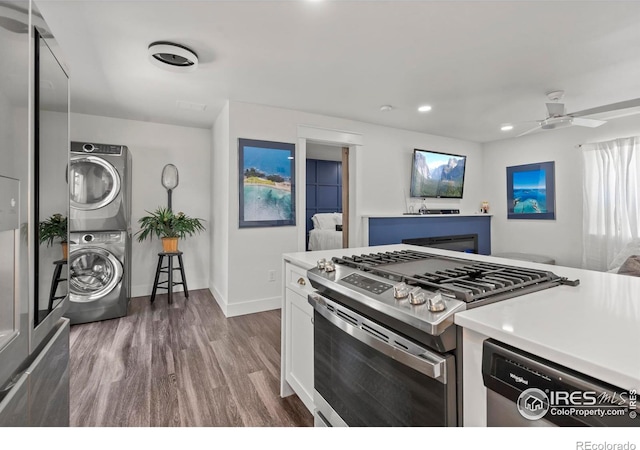 7131 Pontiac St, Commerce City, CO 80022 - kitchen featuring stainless steel appliances, stacked washer / dryer, dark wood finished floors, light countertops, and recessed lighting
