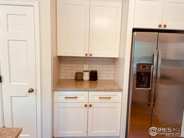 4303 30th St, Boulder, CO 80301 - kitchen with stainless steel refrigerator with ice dispenser, white cabinetry, decorative backsplash, and light stone counters