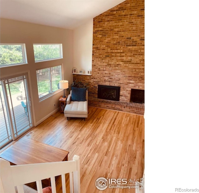 4303 30th St, Boulder, CO 80301 - living room featuring vaulted ceiling, light wood-type flooring, and a fireplace