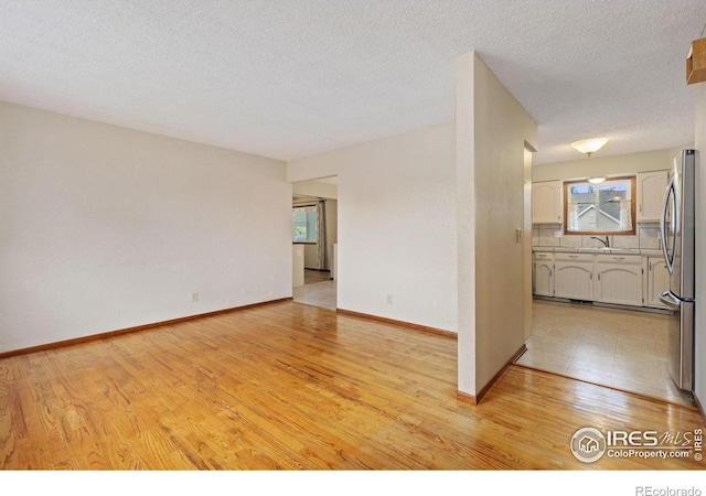 2516 Mountain View Ave, Longmont, CO 80503 - spare room featuring healthy amount of natural light, light wood finished floors, and a textured ceiling