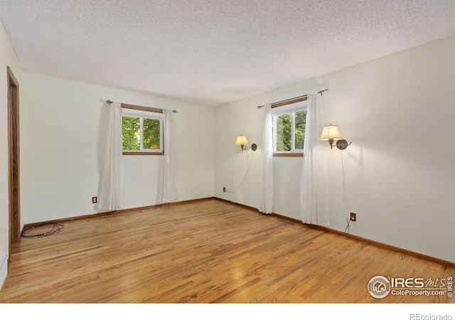 2516 Mountain View Ave, Longmont, CO 80503 - spare room featuring wood finished floors, a textured ceiling, and healthy amount of natural light