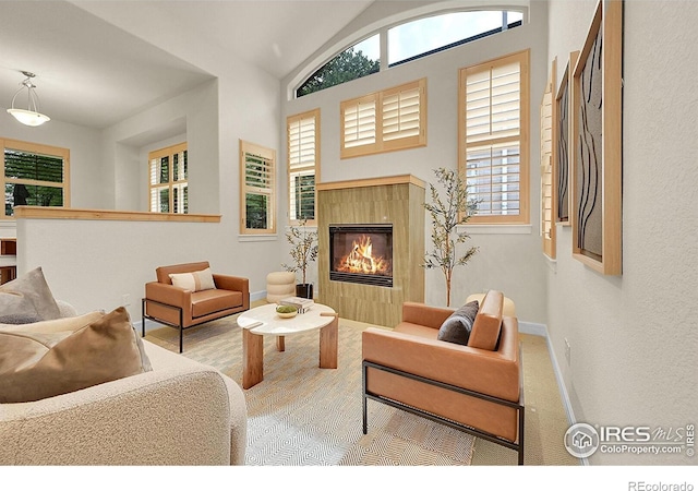 2861 Shoshone Trl, Lafayette, CO 80026 - living room featuring lofted ceiling, a tiled fireplace, and carpet flooring