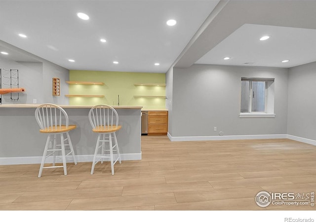 2861 Shoshone Trl, Lafayette, CO 80026 - kitchen with open shelves, a kitchen breakfast bar, light wood-type flooring, recessed lighting, and a peninsula