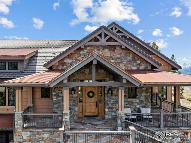 3411 Hillcrest Ln, Estes Park, CO 80517 - view of front of property featuring stone siding, a porch, and a metal roof