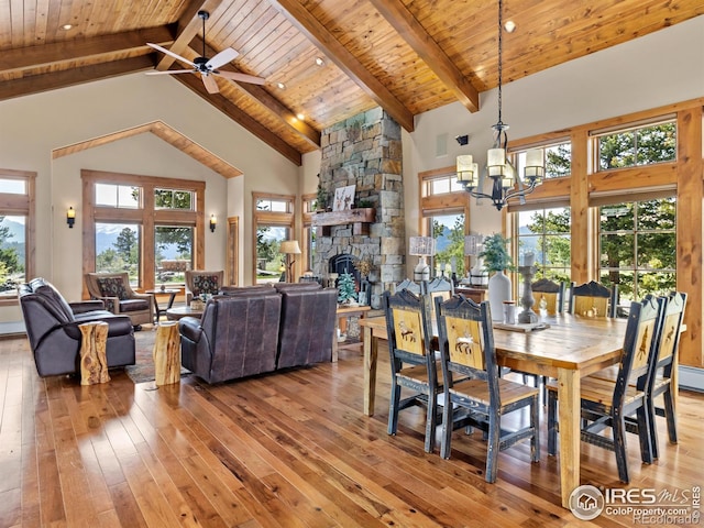 3411 Hillcrest Ln, Estes Park, CO 80517 - dining room featuring light wood-style floors, high vaulted ceiling, a wood ceiling with exposed beams, a chandelier, and a stone fireplace