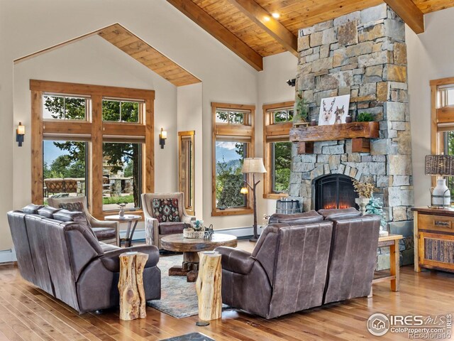 3411 Hillcrest Ln, Estes Park, CO 80517 - living area with a wooden ceiling with exposed beams, wood-type flooring, a stone fireplace, high vaulted ceiling, and a baseboard radiator