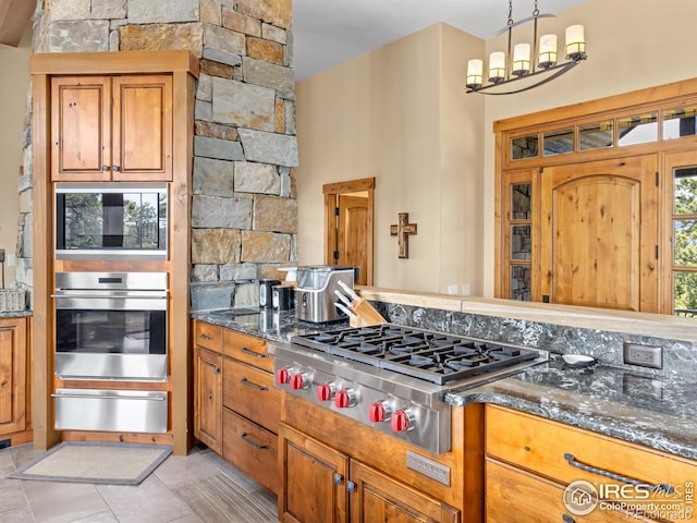3411 Hillcrest Ln, Estes Park, CO 80517 - kitchen featuring stainless steel appliances, a warming drawer, brown cabinets, and dark stone countertops