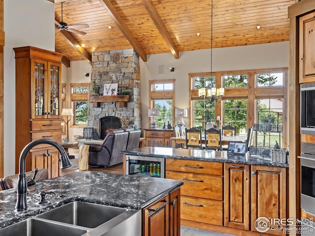 3411 Hillcrest Ln, Estes Park, CO 80517 - kitchen with beverage cooler, a chandelier, wood ceiling, a fireplace, and ceiling fan