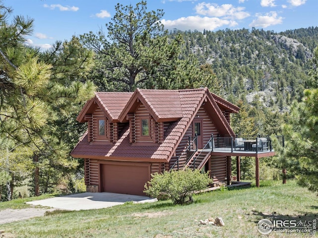 3411 Hillcrest Ln, Estes Park, CO 80517 - cabin with stairway, driveway, a deck, a view of trees, and a garage