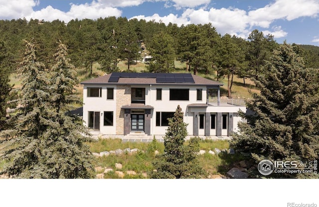 514 Granite Dr, Boulder, CO 80302 - view of front of property featuring french doors, solar panels, stucco siding, and a wooded view