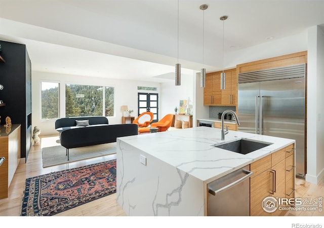 514 Granite Dr, Boulder, CO 80302 - kitchen with appliances with stainless steel finishes, light wood-type flooring, light stone countertops, hanging light fixtures, and brown cabinets