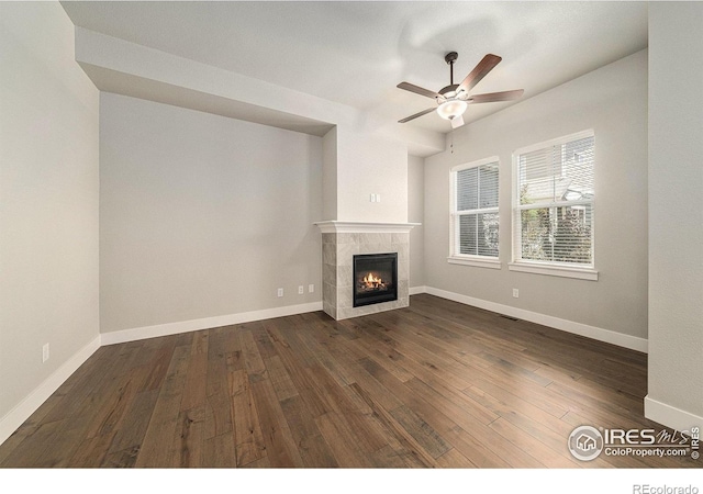 2470 Trio Falls Dr, Loveland, CO 80538 - unfurnished living room with dark wood-style flooring, ceiling fan, and a tiled fireplace