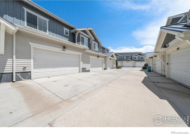 2470 Trio Falls Dr, Loveland, CO 80538 - view of property exterior with board and batten siding, an attached garage, a residential view, and concrete driveway