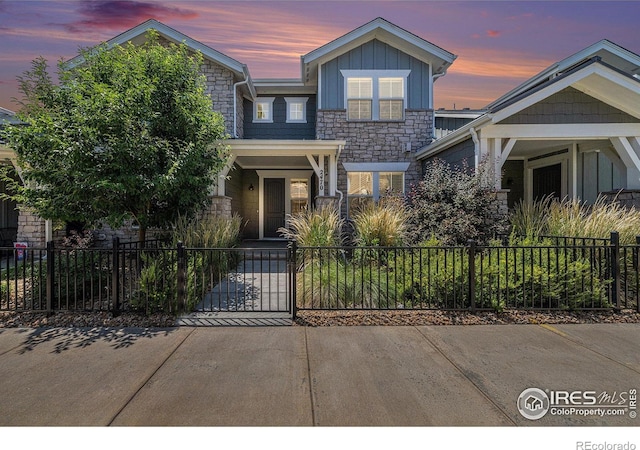 2470 Trio Falls Dr, Loveland, CO 80538 - view of front of house with stone siding, a fenced front yard, and board and batten siding