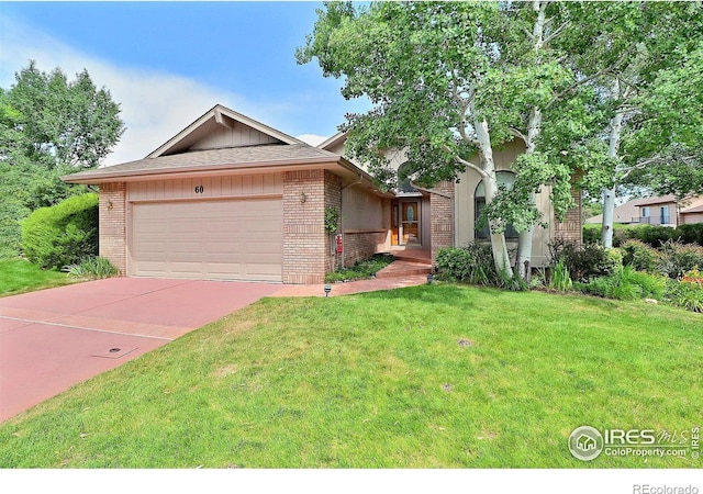 1357 43rd Ave Unit 60, Greeley, CO 80634 - view of front of house with brick siding, a garage, a front yard, and driveway