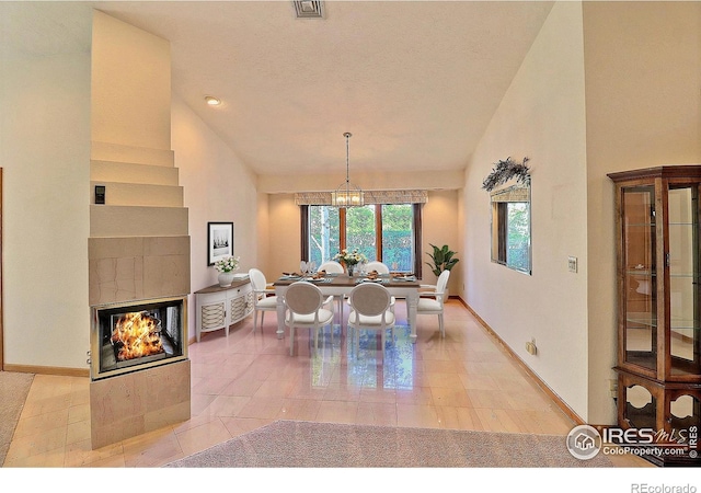 1357 43rd Ave Unit 60, Greeley, CO 80634 - dining area featuring a chandelier, high vaulted ceiling, and a multi sided fireplace