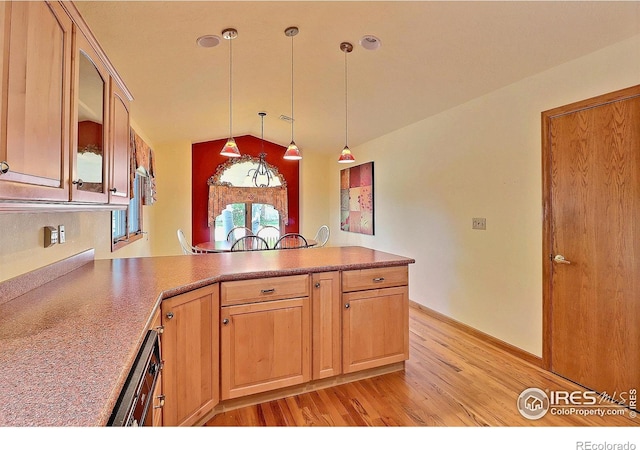 1357 43rd Ave Unit 60, Greeley, CO 80634 - kitchen featuring a peninsula, light wood finished floors, lofted ceiling, glass insert cabinets, and hanging light fixtures