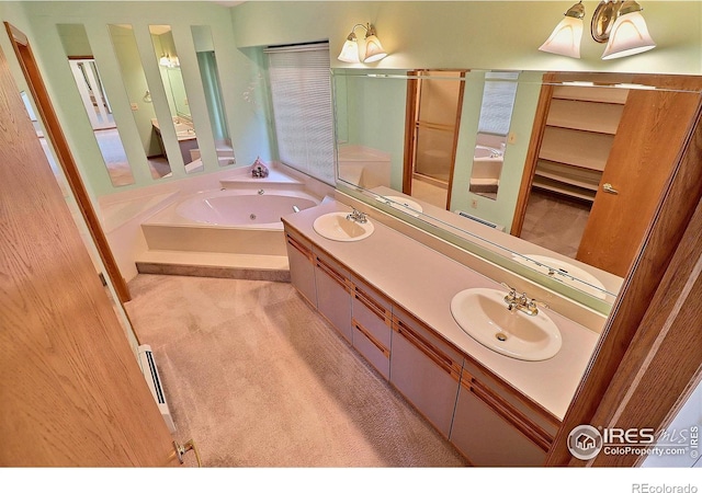 1357 43rd Ave Unit 60, Greeley, CO 80634 - bathroom featuring double vanity, a whirlpool tub, a shower stall, and a baseboard heating unit