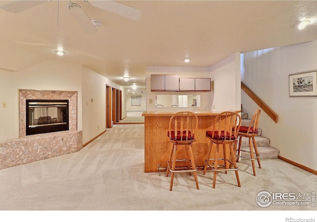1357 43rd Ave Unit 60, Greeley, CO 80634 - kitchen featuring light colored carpet, a kitchen breakfast bar, a peninsula, and gray cabinets