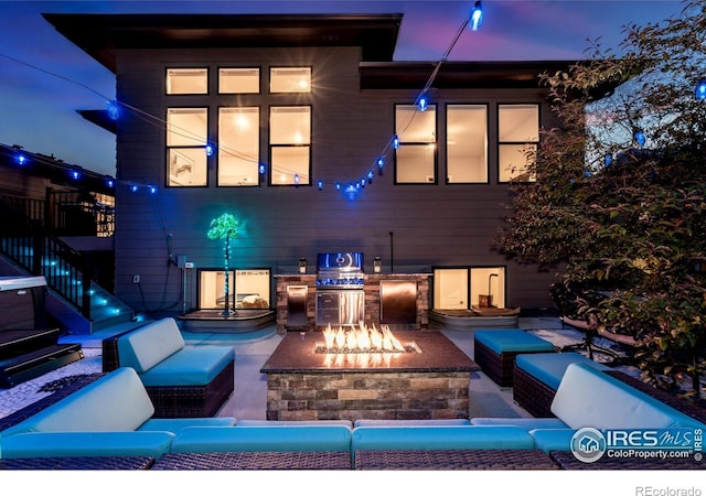 2772 Vallecito St, Timnath, CO 80547 - patio at night featuring an outdoor living space with a fire pit, stairs, a patio, and exterior kitchen