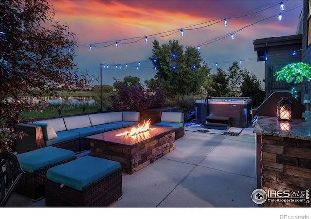 2772 Vallecito St, Timnath, CO 80547 - patio terrace at dusk featuring a hot tub, a patio area, a water view, and an outdoor living space with a fire pit