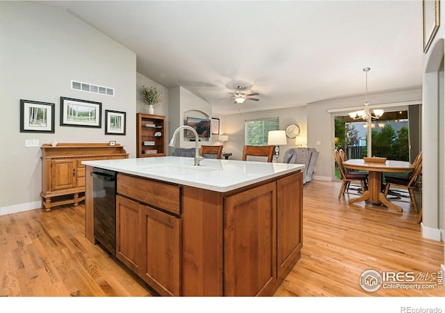 83 Evans St, Severance, CO 80550 - kitchen with dishwasher, brown cabinetry, a chandelier, light wood-style floors, and lofted ceiling