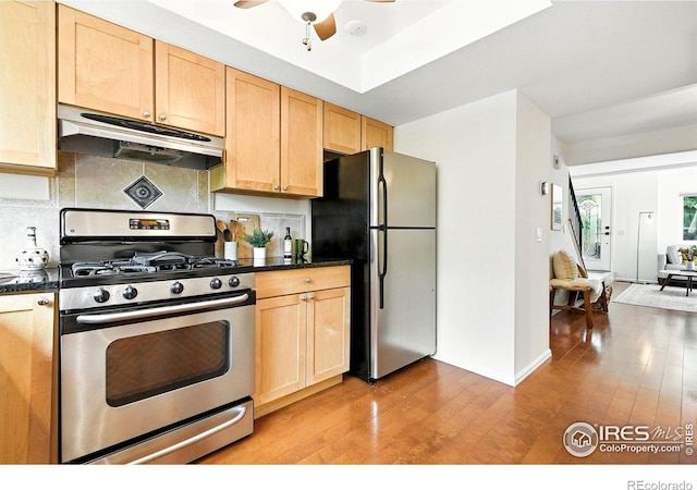 770 Quince Cir, Boulder, CO 80304 - kitchen with stainless steel gas stove, under cabinet range hood, freestanding refrigerator, dark countertops, and light brown cabinets