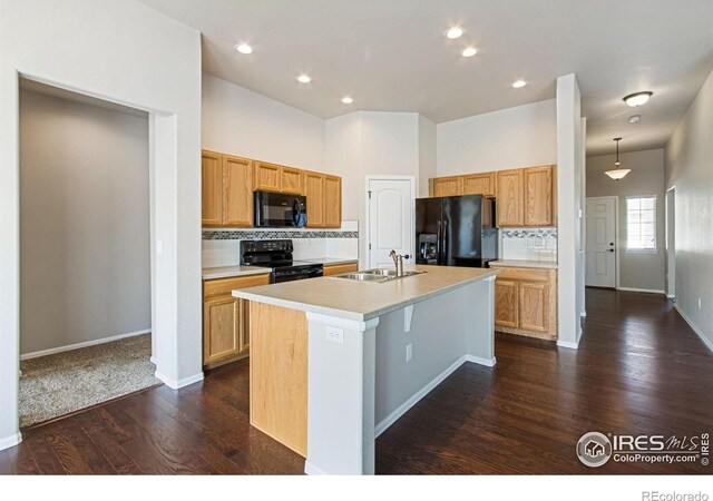 10400 17th St, Greeley, CO 80634 - kitchen featuring black appliances, tasteful backsplash, dark wood-type flooring, a kitchen island with sink, and light countertops