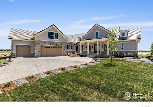 2568 Southwind Rd, Berthoud, CO 80513 - craftsman-style house with a porch, stone siding, an attached garage, a front lawn, and driveway