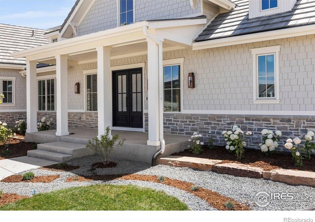 2568 Southwind Rd, Berthoud, CO 80513 - doorway to property featuring covered porch and stone siding