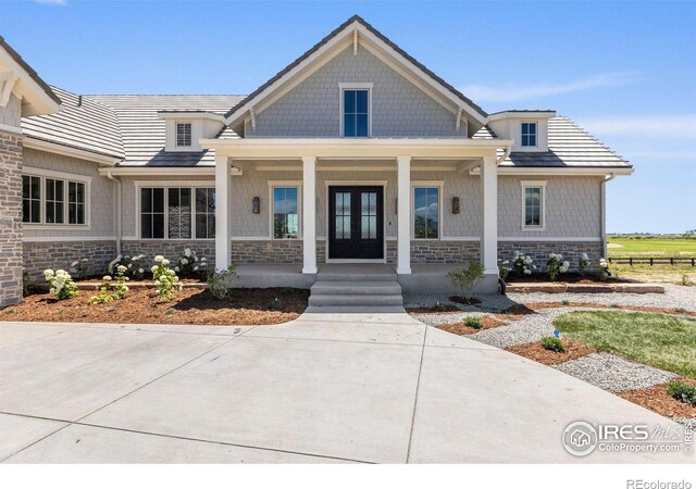 2568 Southwind Rd, Berthoud, CO 80513 - view of front of house featuring stone siding, covered porch, and french doors