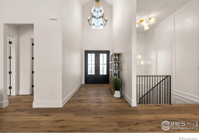 2568 Southwind Rd, Berthoud, CO 80513 - foyer featuring wood finished floors, a chandelier, a decorative wall, french doors, and a towering ceiling