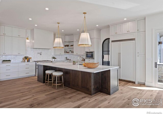 2568 Southwind Rd, Berthoud, CO 80513 - kitchen featuring high quality appliances, light wood-style flooring, tasteful backsplash, white cabinets, and recessed lighting