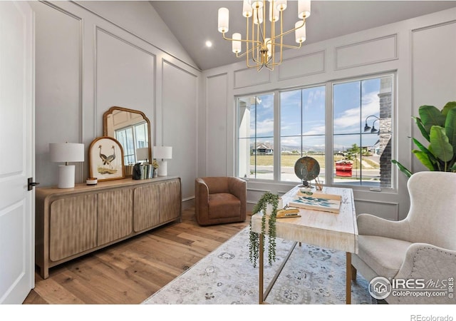 2568 Southwind Rd, Berthoud, CO 80513 - living room featuring wood finished floors, a chandelier, a decorative wall, and lofted ceiling