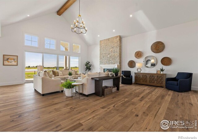 2568 Southwind Rd, Berthoud, CO 80513 - living room featuring high vaulted ceiling, beamed ceiling, wood finished floors, a chandelier, and a brick fireplace