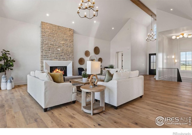 2568 Southwind Rd, Berthoud, CO 80513 - living room featuring a chandelier, high vaulted ceiling, light wood-style flooring, beam ceiling, and a fireplace
