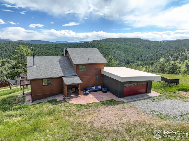 144 Coyote Ct, Boulder, CO 80302 - view of front of property featuring a wooded view, a mountain view, a patio, and a shingled roof