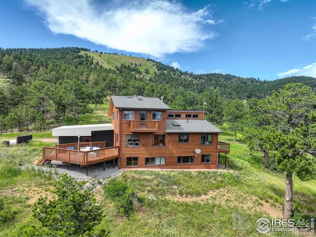 144 Coyote Ct, Boulder, CO 80302 - rear view of house with a forest view, a deck, and roof with shingles