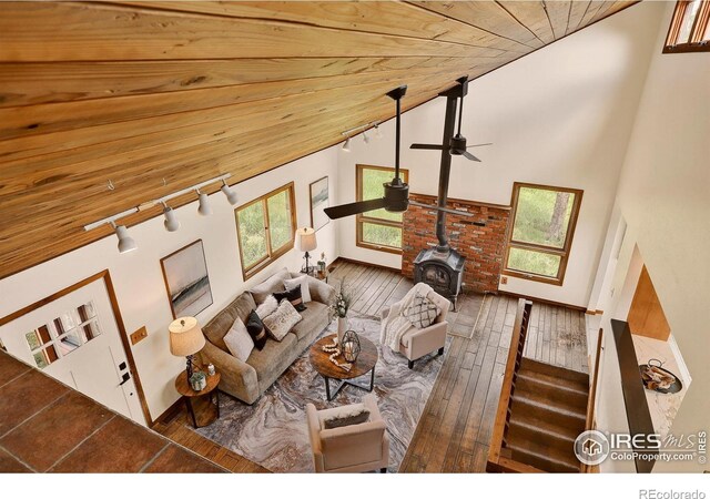 144 Coyote Ct, Boulder, CO 80302 - living room featuring a wood stove, healthy amount of natural light, wooden ceiling, a ceiling fan, and hardwood / wood-style flooring