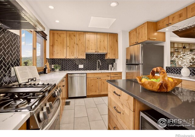 144 Coyote Ct, Boulder, CO 80302 - kitchen with stainless steel appliances, tasteful backsplash, light tile patterned floors, a skylight, and ventilation hood