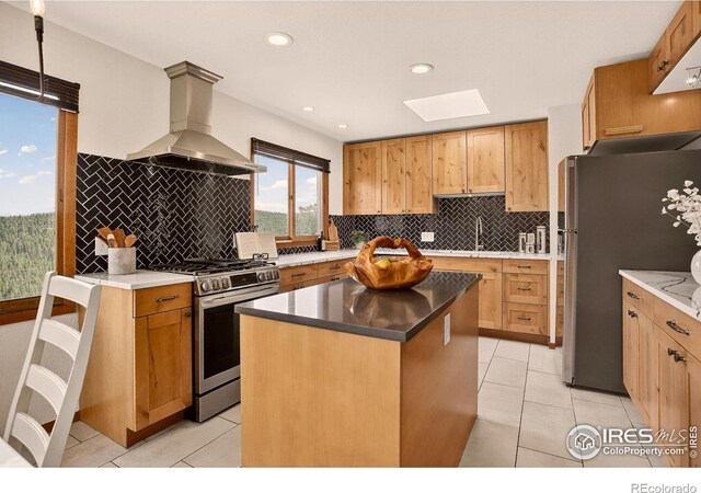144 Coyote Ct, Boulder, CO 80302 - kitchen featuring appliances with stainless steel finishes, island exhaust hood, a skylight, decorative backsplash, and light tile patterned floors