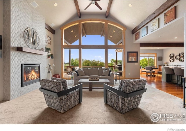 37044 Soaring Eagle Cir, Severance, CO 80550 - living room with beam ceiling, wood finished floors, ceiling fan, a glass covered fireplace, and high vaulted ceiling