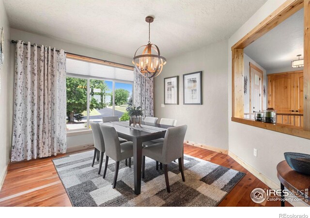 37044 Soaring Eagle Cir, Severance, CO 80550 - dining space featuring a chandelier and wood finished floors