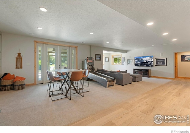 37044 Soaring Eagle Cir, Severance, CO 80550 - carpeted living area with hardwood / wood-style flooring, a textured ceiling, recessed lighting, and french doors